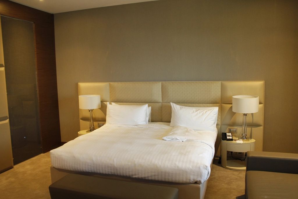 A guest room with a large bed and soft lighting